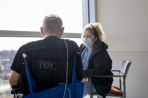 RPN sitting with patient in wheelchair facing a window